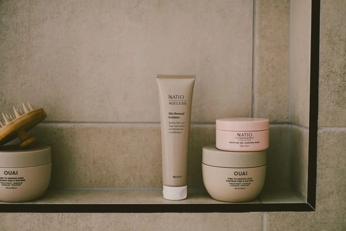 Skin care products lined up on a minimalist bathroom shelf