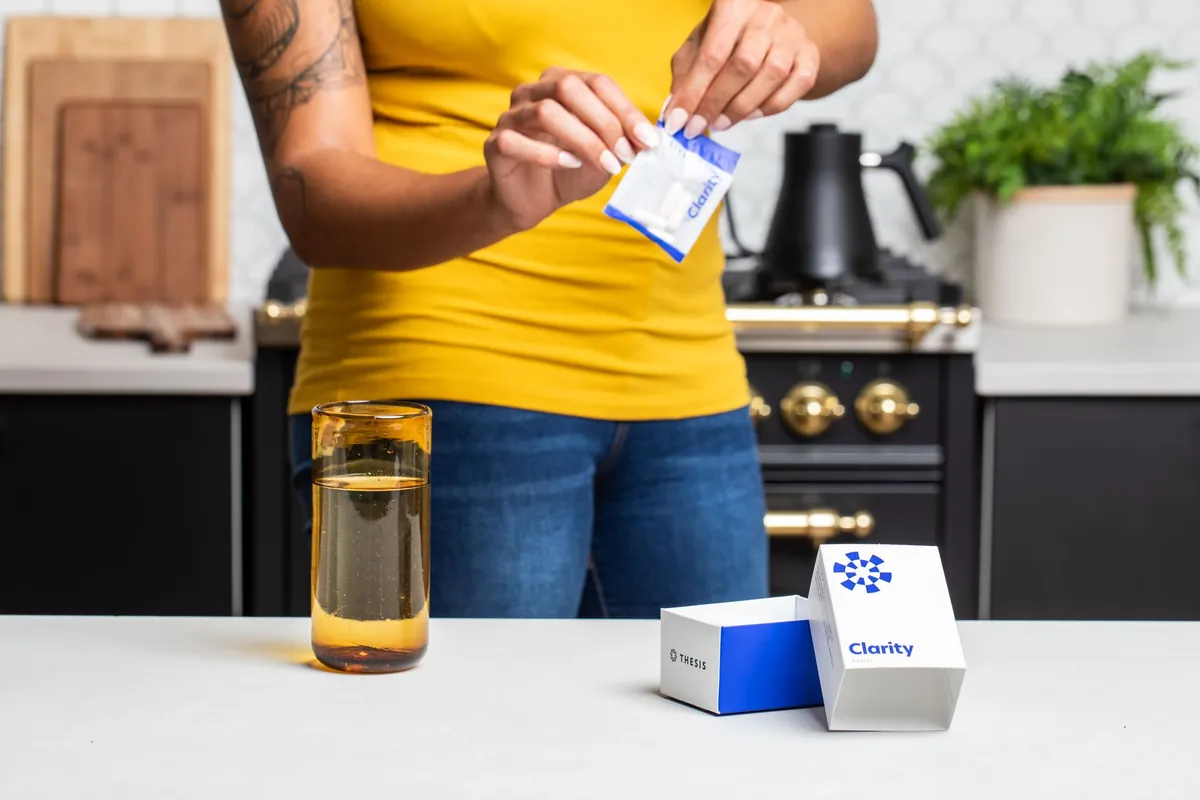 Close-up of hands tearing open a supplement drink sachet in a home kitchen, the kind of shot used as UGC b-roll